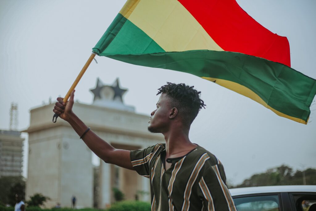 A Ghanaian man holding the Ghana flag
