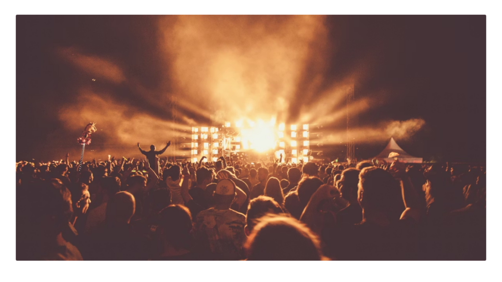 High contrast silhouette of a concert crowd overlaid with digital data interference.